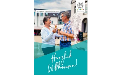 Das Titelbild des Gastgeberverzeichnisses ist 2021 Gelb. Herzlich Willkommen steht darauf. Das Foto zeigt eine Draufsicht auf die Außenbecken der Therme und das Gradierwerk im Hintergrund.